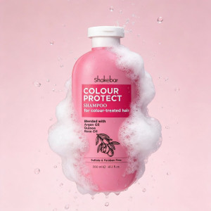Pink Shakebar Colour Protect Shampoo bottle for colour-treated hair with foamy bubbles on a pink background.